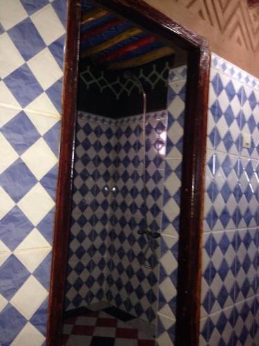 a mirror in a room with blue and white tiles at Chegaga Nomad Camp in El Gouera