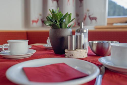 a table with a red table cloth and a plate with a red napkin at Beim Kathrein - inklusive SILVRETTA Card Premium in Galtür