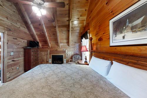 a bedroom with a large bed in a room with wooden walls at Chalet of Dreams in Pigeon Forge