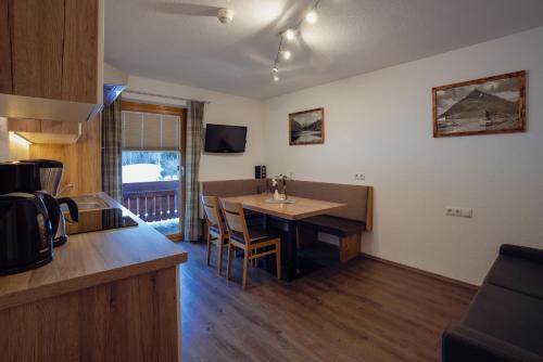 a kitchen and dining room with a table and chairs at Beim Kathrein - inklusive SILVRETTA Card Premium in Galtür
