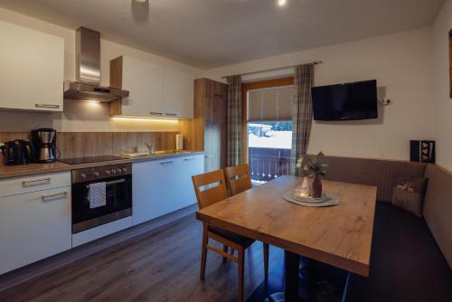 a kitchen and dining room with a table and a couch at Beim Kathrein - inklusive SILVRETTA Card Premium in Galtür