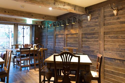 バーンリーにあるBarley Mowの木製の壁とテーブルと椅子が備わるレストラン