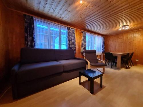 Chalet Engi Apt 2 for up to 6 People في جريندلفالد: غرفة معيشة مع أريكة وطاولة