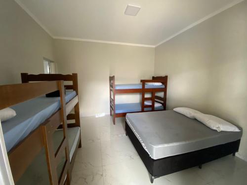 a room with two bunk beds in a room at Casa De Temporada Eldorado 2 in Olímpia