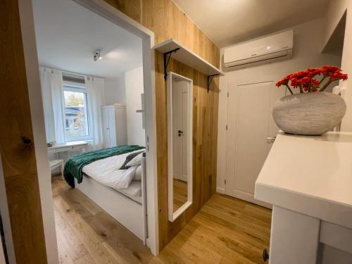 Habitación pequeña con cama y jarrón en la encimera en URBAN APARTMENTS COSY No 4 Chorzów Katowice, FREE PRIVATE PARKING en Chorzów