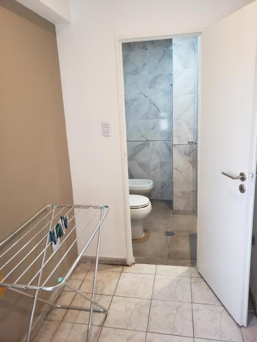 La salle de bains est pourvue de toilettes et d'une porte de douche en verre. dans l'établissement Prema, à San Miguel de Tucumán