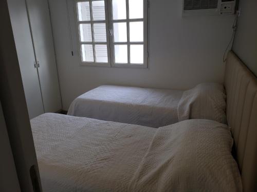 two beds in a small room with a window at Prema in San Miguel de Tucumán