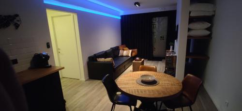 a living room with a table and a couch at De Konik in Uikhoven