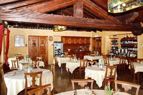 a restaurant with white tables and chairs and a bar at Les Combes in La Salle