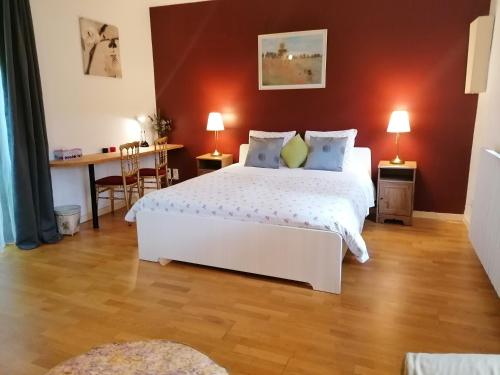 a bedroom with a large white bed and a table at Gîte dans un Domaine Historique in Chevreuse