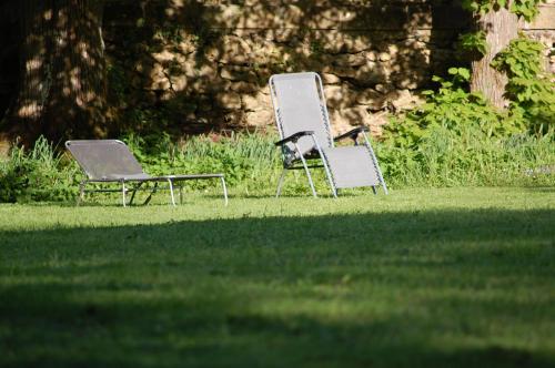 two chairs sitting in the grass in a yard at Gîte dans un Domaine Historique in Chevreuse