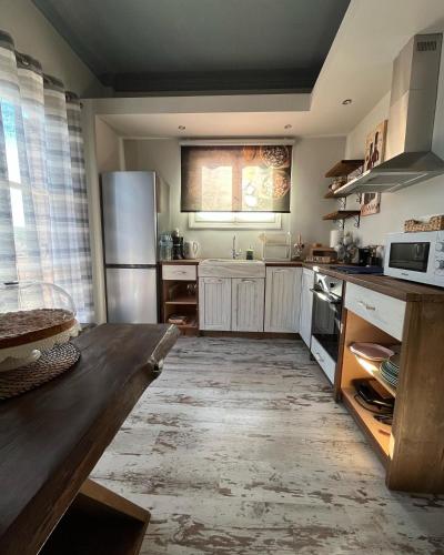 a kitchen with a wooden table and a refrigerator at Galaxidi Sea View Apartment , Galaxidi in Galaxidhion