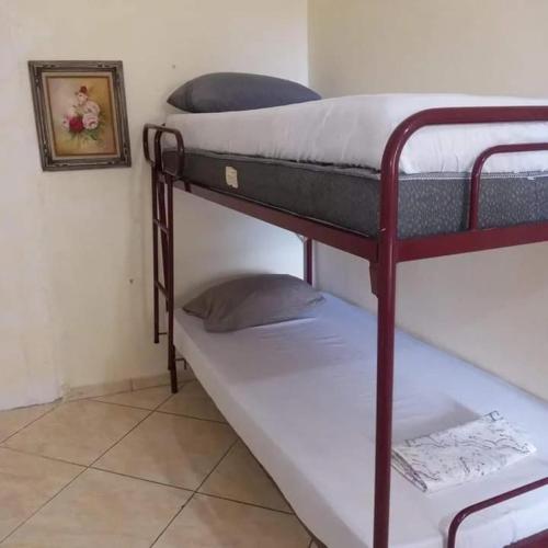 two bunk beds in a room with a picture on the wall at Mayda hostel in Praia Grande
