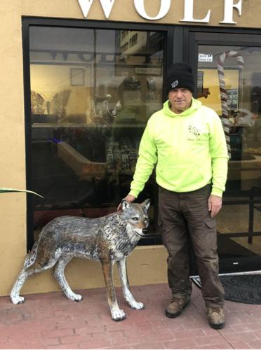 a man standing next to a statue of a wolf at Wolf Inn Hotel in Sandusky