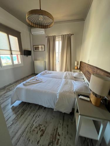 a bedroom with a large white bed and a desk at Galaxidi Sea View Apartment , Galaxidi in Galaxidhion