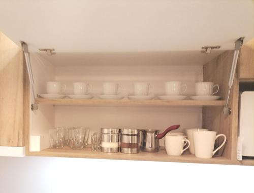 a cupboard with dishes and cups on it at Lena in Banja Koviljača