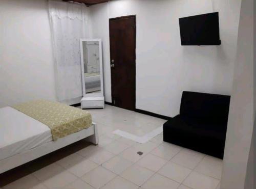 a bedroom with a bed and a chair and a television at 1IF2-2APARTAMENTO EN CARTAGENA CERCA AL MAR CON AIRE ACONDICIONADO Y WIFi in Cartagena de Indias