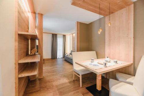 a living room with a table and a couch at Cesa Edelweiss Living & Spa in Campitello di Fassa