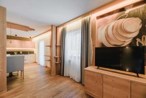 a living room with a large flat screen tv at Cesa Edelweiss Living & Spa in Campitello di Fassa