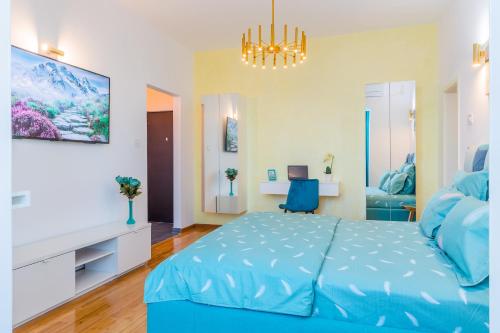 a bedroom with a blue bed and a chandelier at New Studio Carturesti - City Center in Bucharest