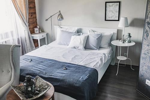 a bedroom with a large bed with a blue blanket at Penzion Adamův Dvůr in Masákova Lhota