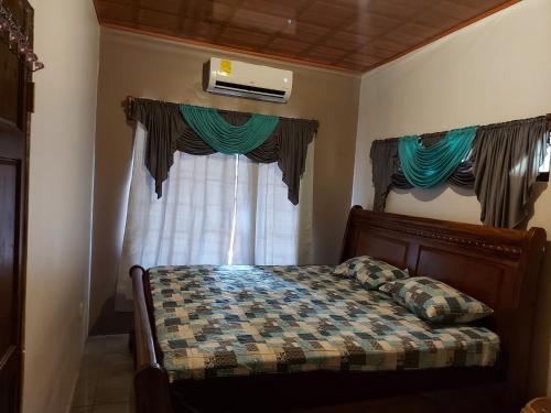a bedroom with a bed and a window with curtains at Casa a sólo 5 minutos de Paso Canoas in La Cuesta