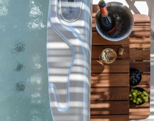 a table with a bottle of wine and a bowl of grapes at Sea & Olives Suites Hotel and Villas in Plaka