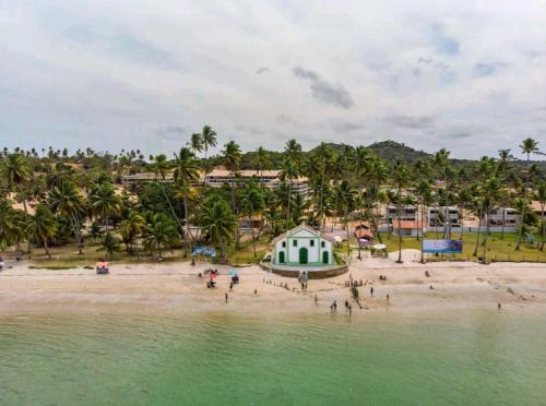 普拉亚多斯卡内罗斯LINDO Flat Eco Resort - melhor trecho da praia de Carneiros的一群人在靠近水边的海滩上