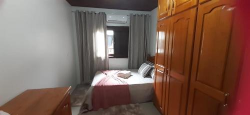 a small bedroom with a bed and a window at Pousada Paraíso dos Canyons in Praia Grande