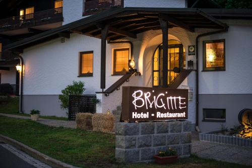 a sign for a hotel restaurant in front of a house at Hotel Restaurant Brigitte in Warmensteinach