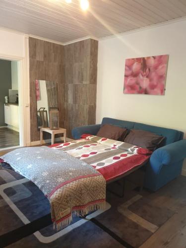 1 dormitorio con 1 cama y 1 sofá azul en Majoitus Eura en Kauttua