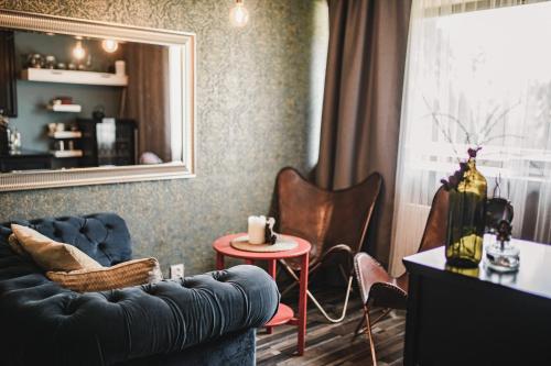a living room with a blue couch and a table at Penzion Adamův Dvůr in Masákova Lhota