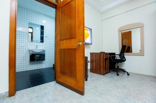 an open door to a bathroom with a sink and a desk at Sam's Cottage Hotel in Dzorwulu