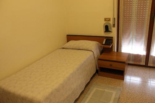 a bedroom with two beds and a wooden table at Hotel O'Scugnizzo 2 in Belluno