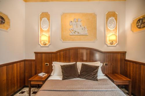 a bedroom with a bed and two lights on the wall at Nakissa Inn in Rome