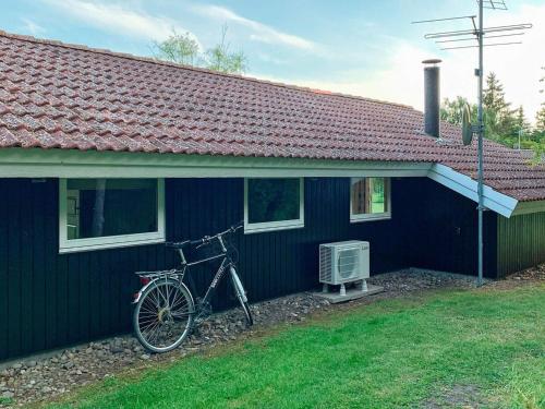 una bicicleta estacionada fuera de una casa azul en 8 person holiday home in Slagelse, en Store Kongsmark