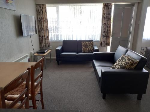 a living room with two couches and a table at Comfort Inn Tayesta Motel in Invercargill