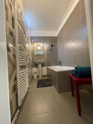 a bathroom with a bath tub and a sink at Le Cosy in Schiltigheim