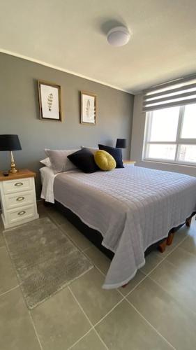 Un dormitorio con una cama grande y una ventana en Apart Center Temuco, en Temuco