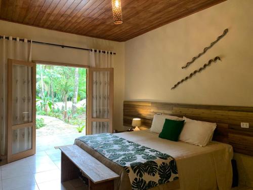 a bedroom with a bed and a sliding glass door at Glamping Mangarito in Iporanga
