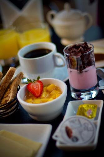a table with a cup of coffee and a bowl of fruit at La Blanca Hotel in Viña del Mar