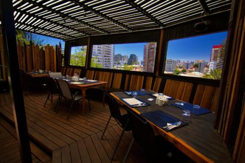 a restaurant with tables and chairs in a room with windows at La Blanca Hotel in Viña del Mar