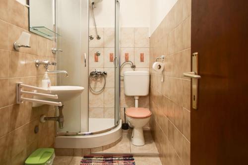 y baño con ducha, aseo y lavamanos. en Apartments Derado, en Supetar