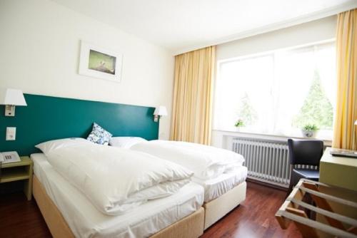 a hotel room with two beds and a window at Landgasthof Läuterhäusle in Aalen
