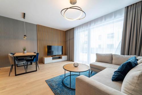 a living room with a couch and a table at Lake Chill Apartment in Ostróda