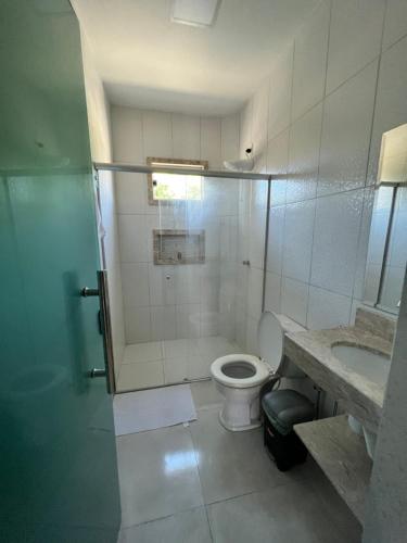 a bathroom with a toilet and a shower and a sink at Pousada dos Duques in Prado