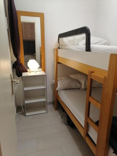 - une chambre avec 2 lits superposés et un miroir dans l'établissement Studio cabine valras plage 300m de la mer, à Valras-Plage