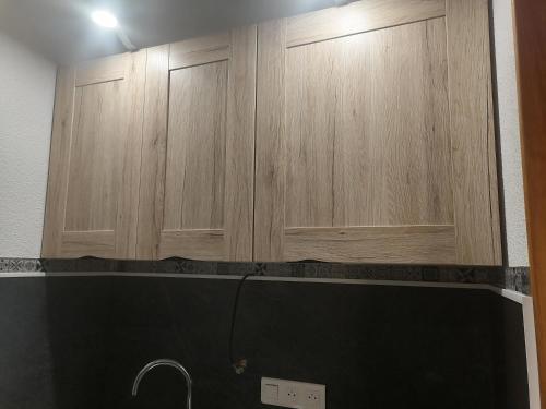 two wooden cabinets above a sink in a kitchen at Studio cabine valras plage 300m de la mer in Valras-Plage