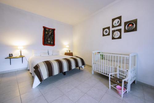 a bedroom with a bed and a crib in it at Os 5 Sentidos in Mourão