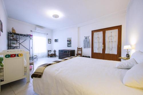 a bedroom with a large white bed in a room at Os 5 Sentidos in Mourão